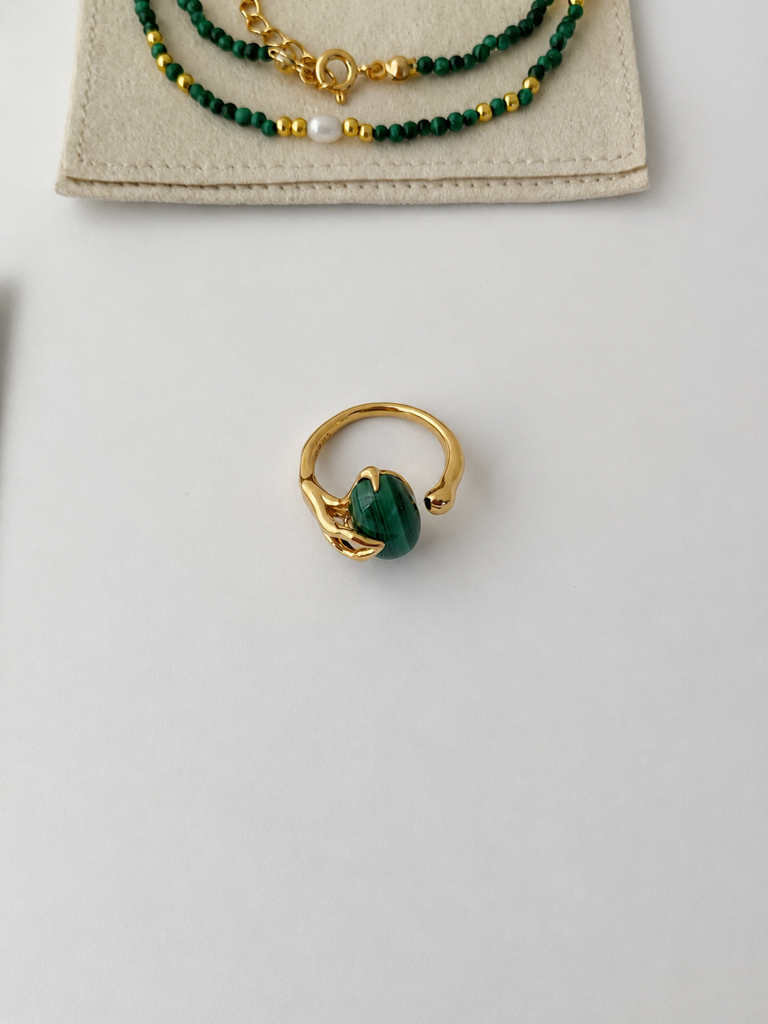 Oval natural malachite with rich green banding on gold-plated S925 silver. Sculptural prongs, open adjustable band.