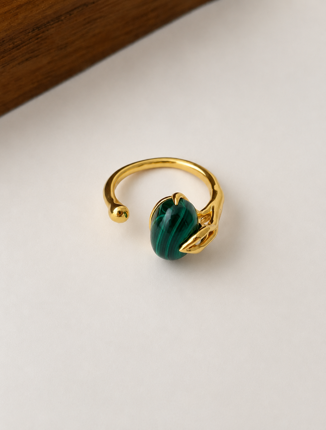 Oval natural malachite with rich green banding on gold-plated S925 silver. Sculptural prongs, open adjustable band.