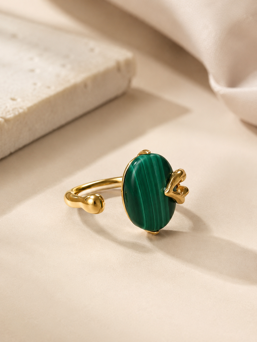 Oval natural malachite with rich green banding on gold-plated S925 silver. Sculptural prongs, open adjustable band.