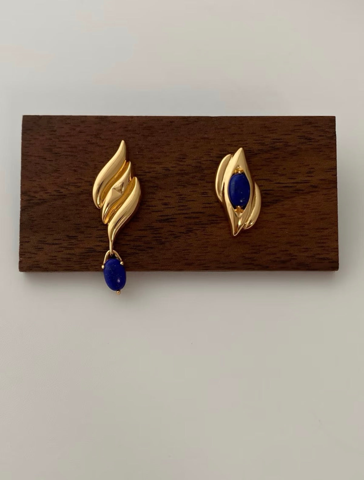 Asymmetric lapis lazuli earrings in gold-plated S925 silver. One set stone, one swinging drop. Sculptural design.