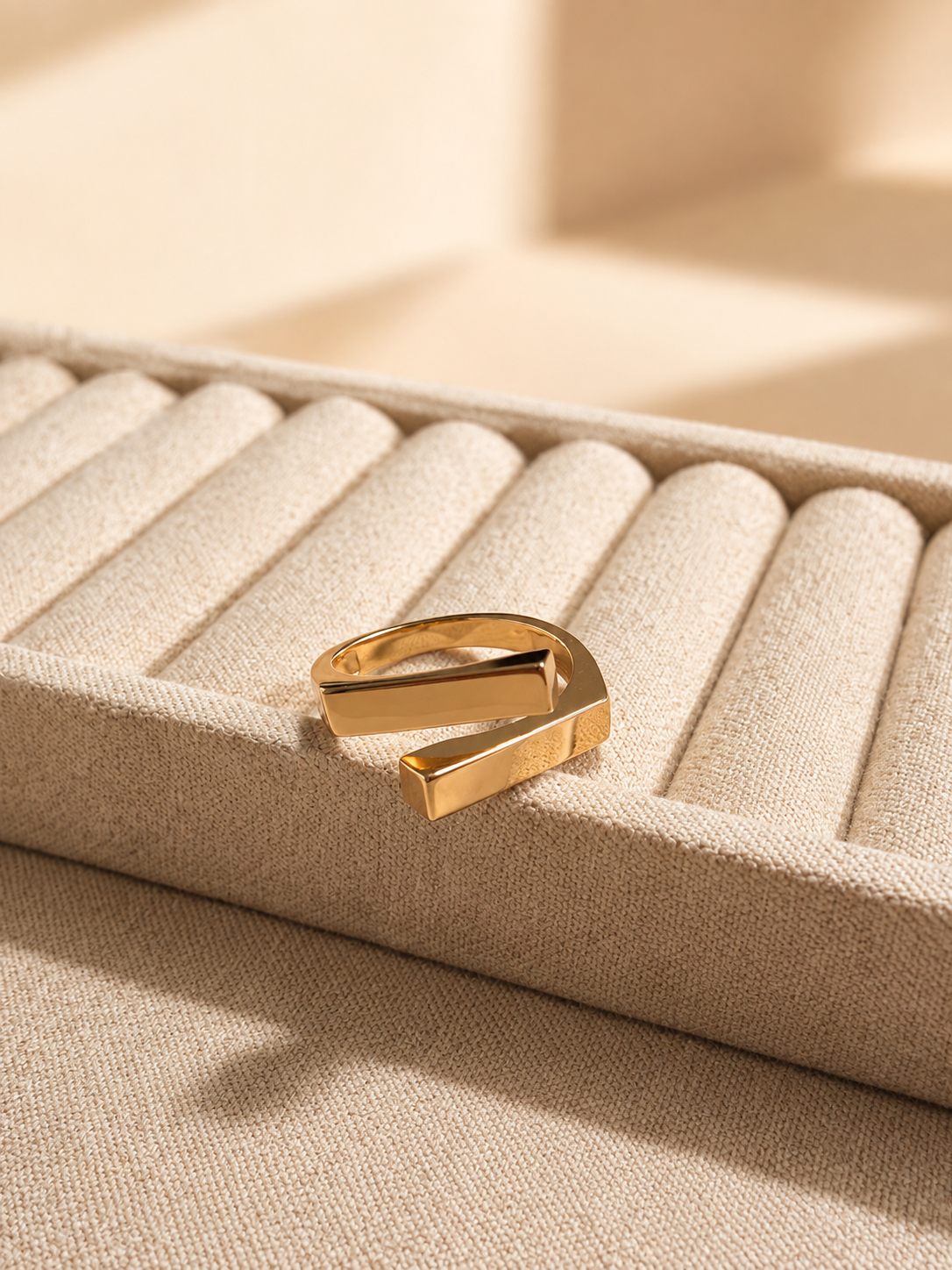 Two square bars cross in a clean geometric silhouette, on gold-plated S925 silver. Open adjustable, minimalist design.