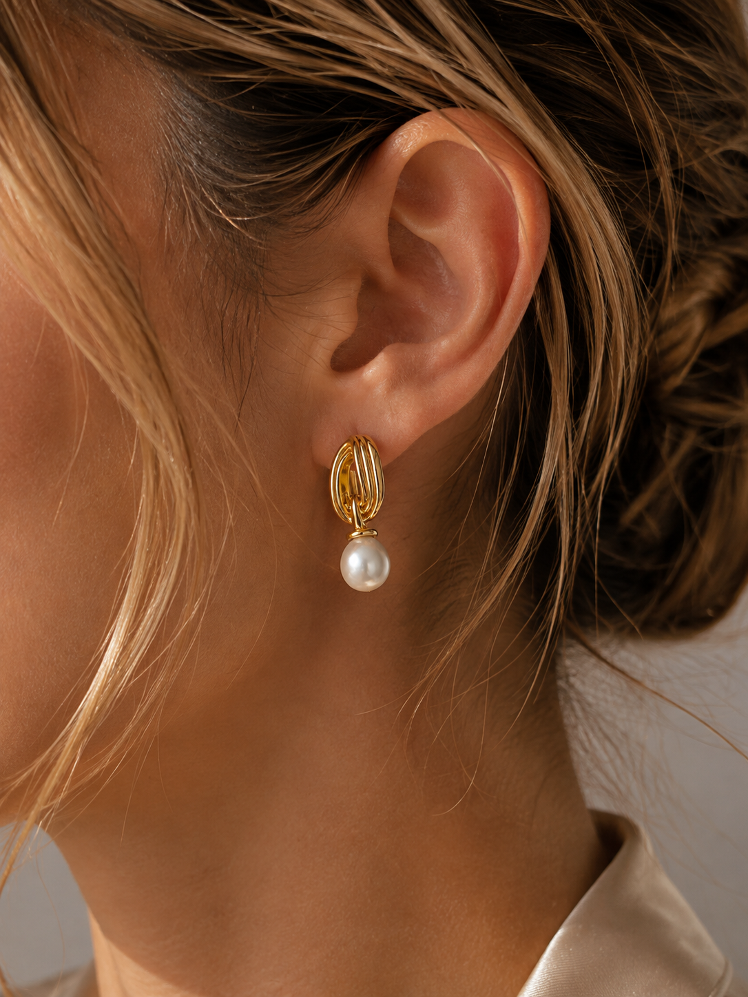 Mobius-inspired gold bands with a freshwater pearl drop, in 18K gold-plated S925 silver. Secure post closure.
